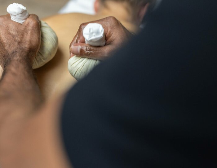Jambira Pinda Sweda at Kristall Spa A person receives a Jambira Pinda Sweda treatment with warm herbal boluses at the Kristall Spa.