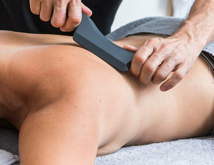 Sport special massage at Kristall Spa A woman receives a sport special massage at Kristall Spa while her back is treated with a massage device.