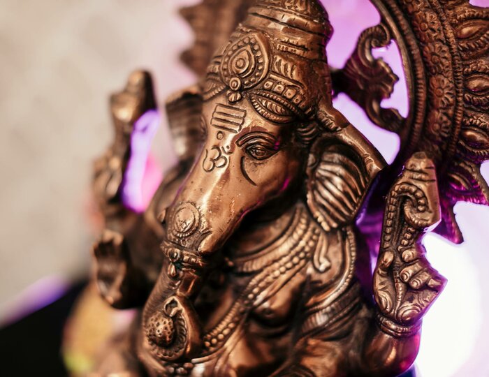 Bronze Ganesha figure in Kristall Spa A bronze Ganesha figure is shown against a light background with purple lighting.